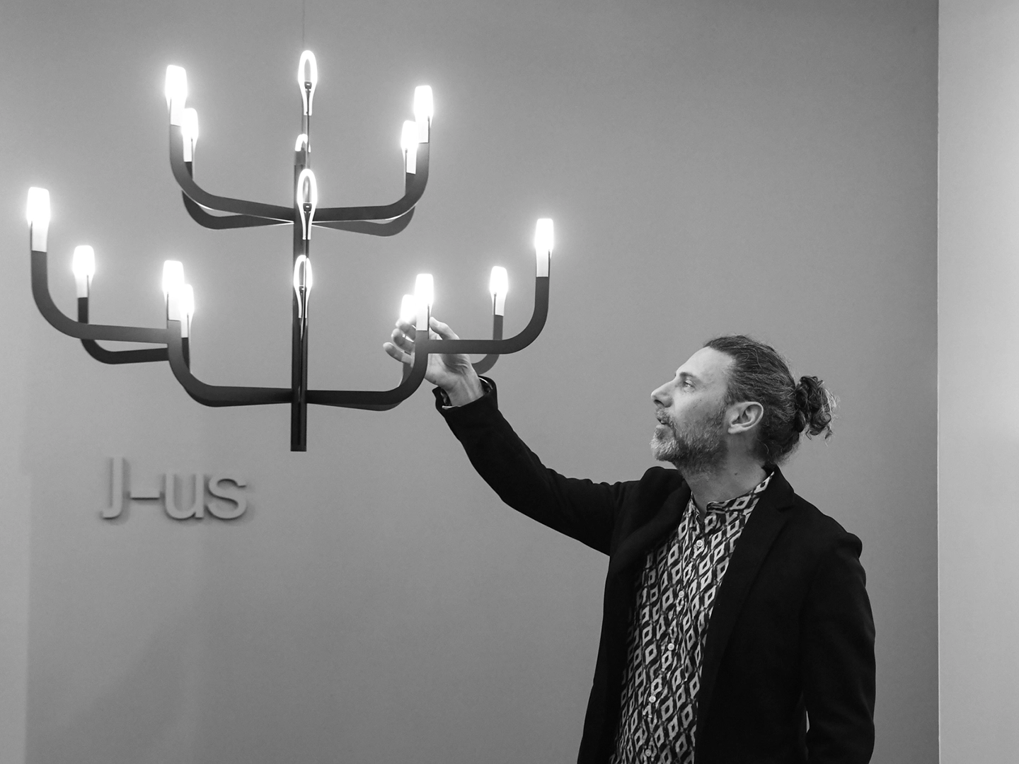 The designer of J-us, Alessandro Zambelli, is portrayed with the lamp